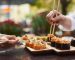 Two,Women,Sitting,In,Asian,Restaurant,And,Eating,Sushi,Set